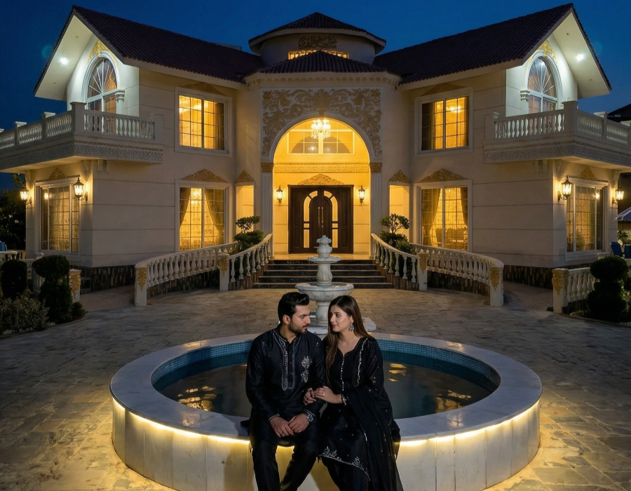 Elegant couple sitting by a lit fountain at a luxury farmhouse in Islamabad during a romantic anniversary photoshoot at night