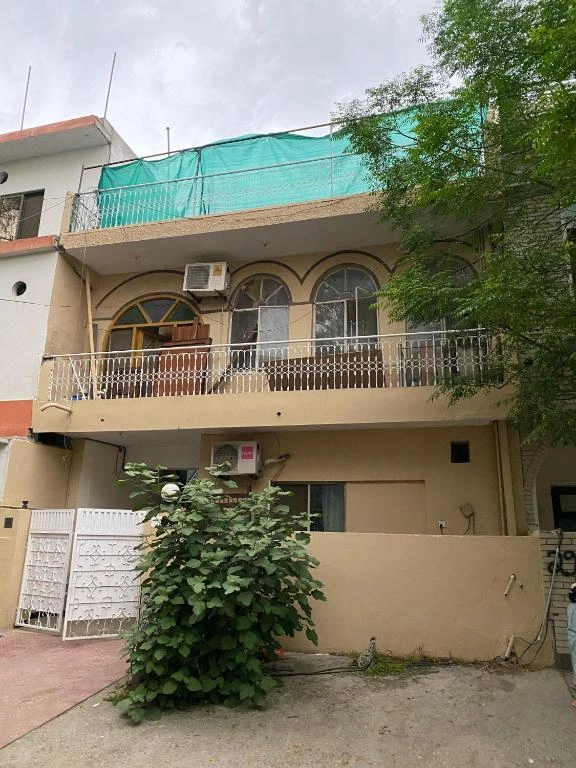 Exterior of a budget-friendly guest house in Islamabad with balcony, greenery, and simple architecture offering comfortable stays in 2026.