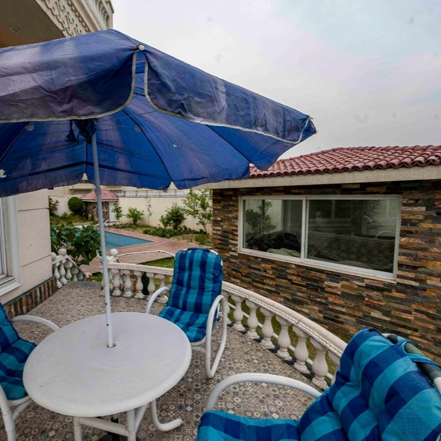 Private outdoor seating at a luxury farm house in Islamabad for rent with pool views near Islamabad Airport.
