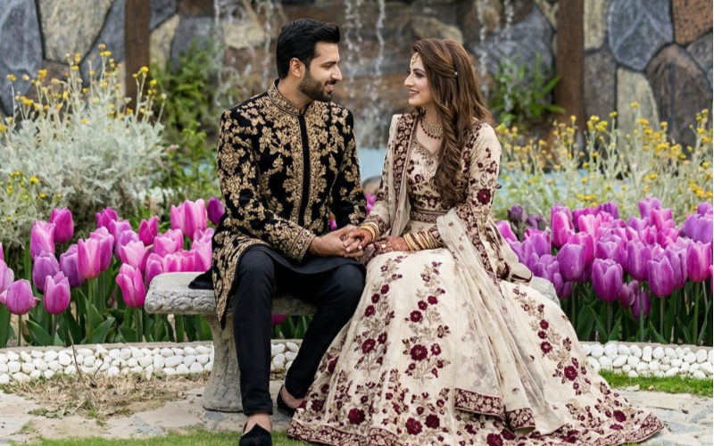 Couple posing among colorful flowers for a romantic Mehndi photoshoot, showcasing elegant Mehndi photoshoot ideas