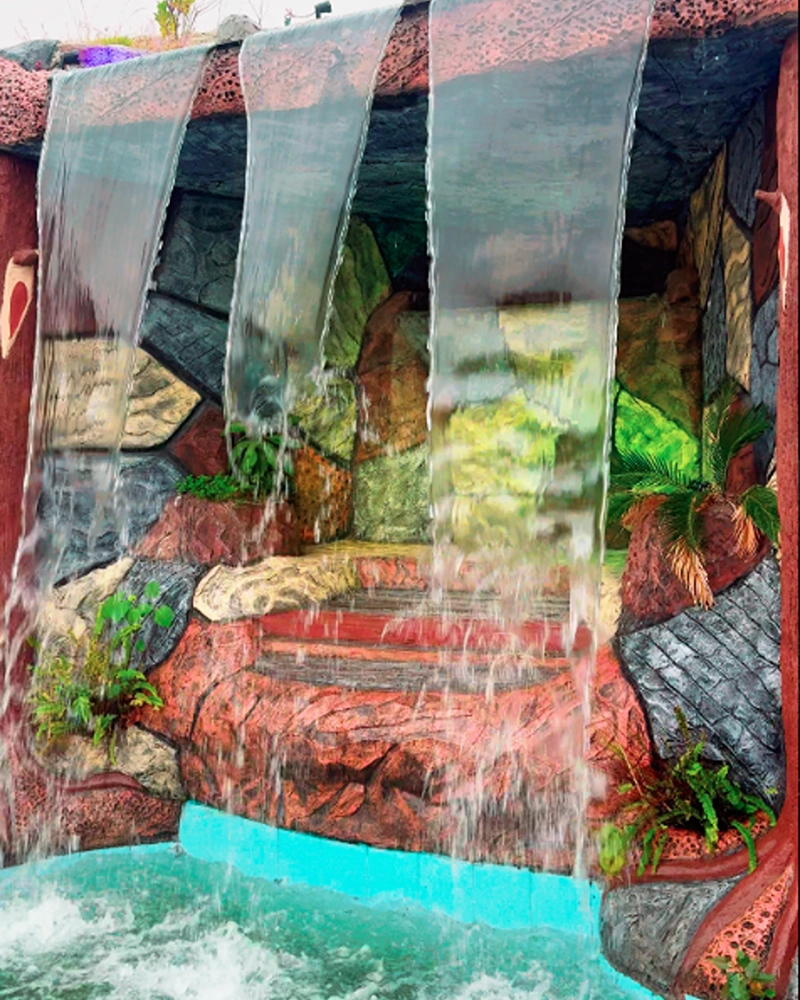 Scenic waterfall and pool at a luxury farm house in Islamabad for rent near Islamabad Airport with premium outdoor facilities.