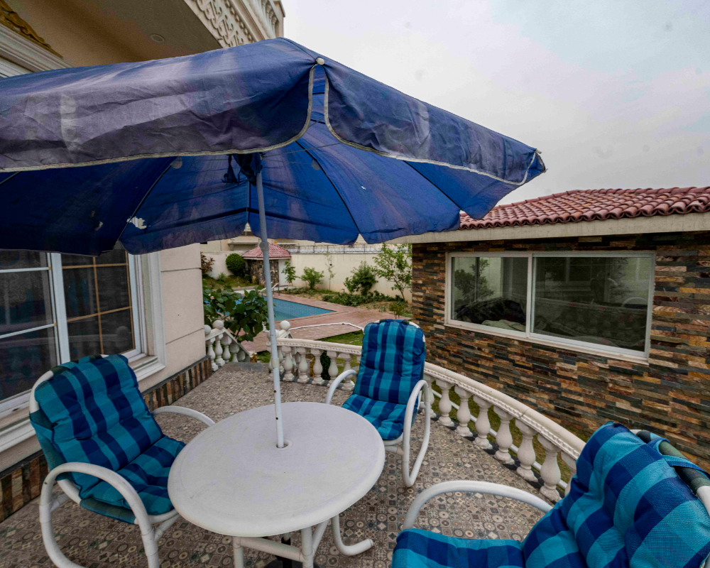 Luxury farmhouse outdoor seating near Islamabad with terrace dining area and relaxing event space at AH Royal Resort