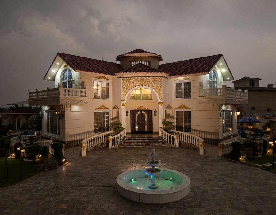 Luxury farmhouse exterior with fountain at night, ideal private photoshoot venue in Islamabad with elegant architecture