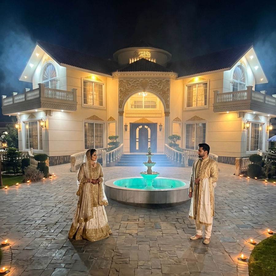 Bride and groom posing at AH Royal Resort Islamabad at night with fountain, lights, and luxury venue for bridal photoshoot
