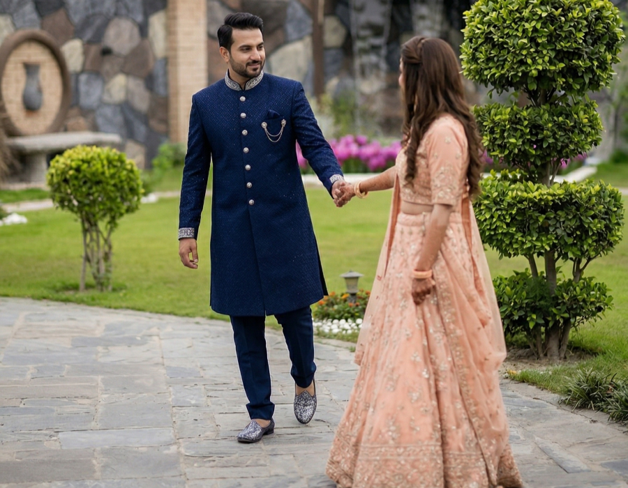 Couple in traditional outfits walking hand in hand in a garden during a romantic anniversary photoshoot at a farmhouse in Islamabad
