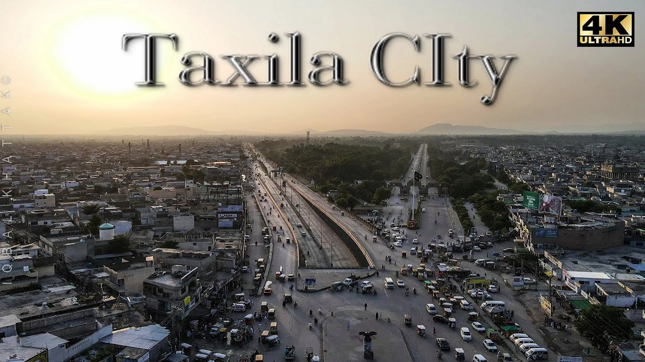 Aerial view of Taxila City at sunset showing busy roads, urban buildings, and surrounding hills near Islamabad for travelers in 2026.