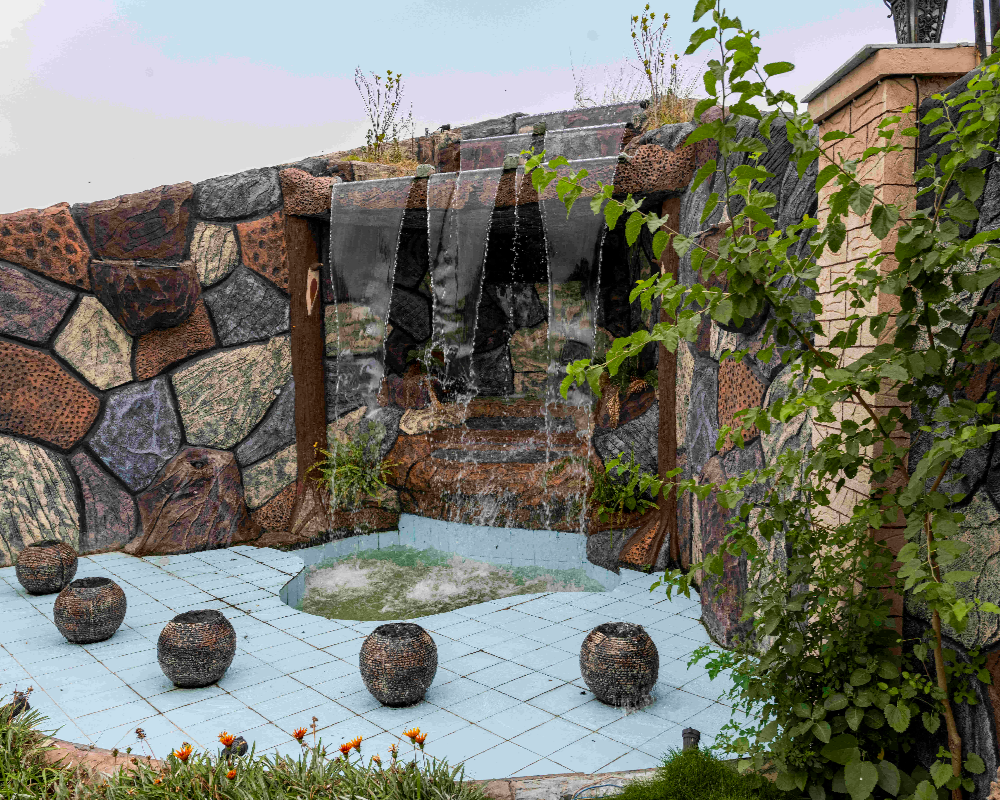 Scenic waterfall feature with stone backdrop, elegant private photoshoot venue in Islamabad resort for luxury photography
