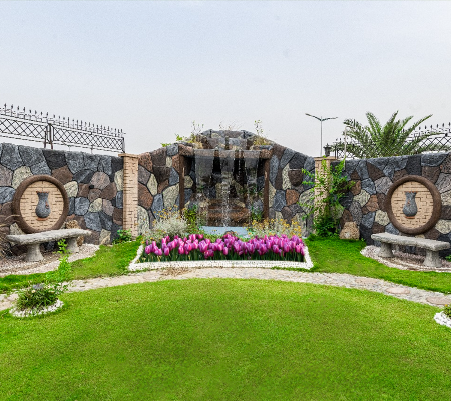 Luxury wedding photoshoot garden in Islamabad with waterfall feature, landscaped lawn, and royal outdoor venue setting